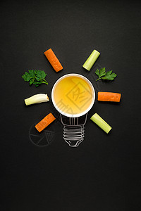 创意照片的盘子与蔬菜安排为灯泡黑色背景图片