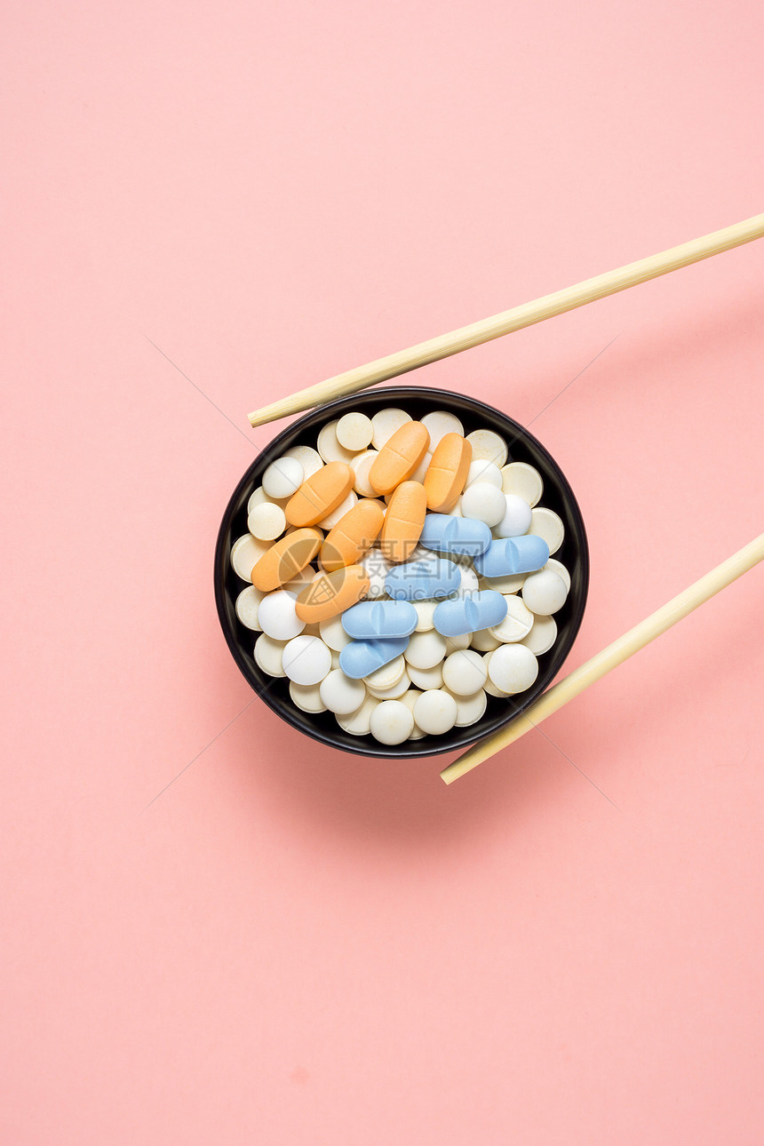 创意照片的药丸安排为寿司粉红色背景图片