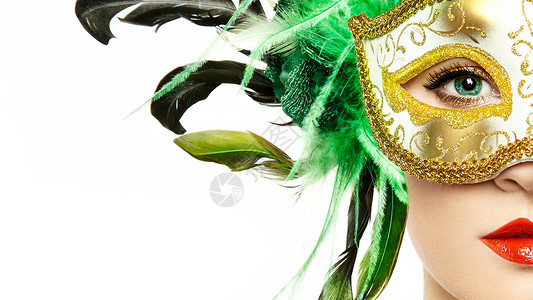 美丽的轻女人戴着神秘的金色威尼斯具时尚照片用绿色羽毛伪装具图片