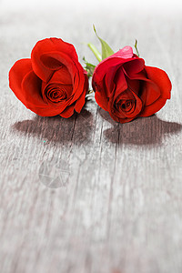心形玫瑰两朵心形的红色玫瑰木制背景上,情人节图片