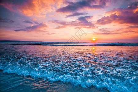 日落海洋上美丽的日落天空背景前溅海浪图片