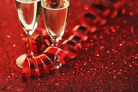 带香槟红色闪光背景的礼物的眼镜闪光的香槟图片