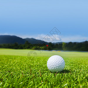 球场上的高尔夫球球场上的高尔夫球,背景上山的美丽景观背景图片