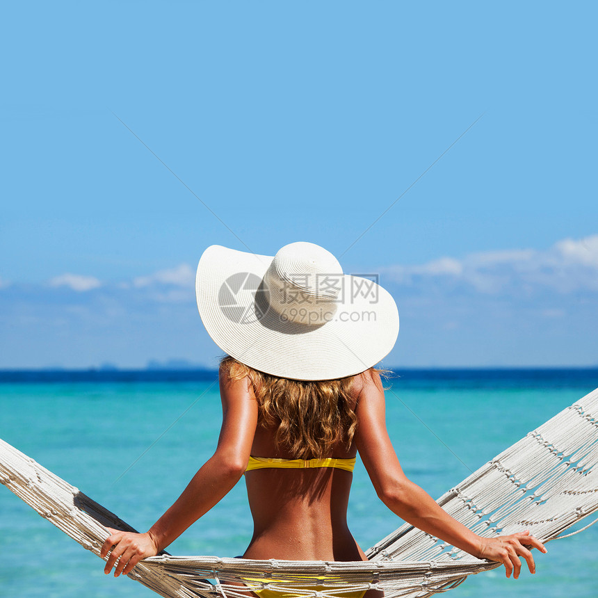 穿着太阳帽的女人悍马里摆穿着太阳帽的女人蓝色的海洋背景上悍马上摆图片