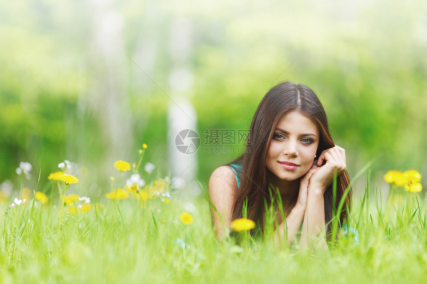 轻漂亮的女人躺新鲜的绿草上,开着花花田上的女人图片
