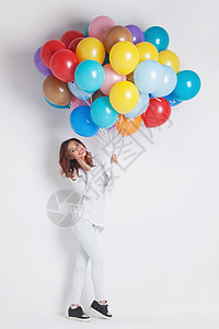 带气球的快乐女人快乐的女人,白色的气球上许多五颜六色的气球图片