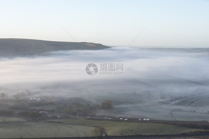 美丽的雾状英国乡村景观日出冬天,层层滚动田野图片