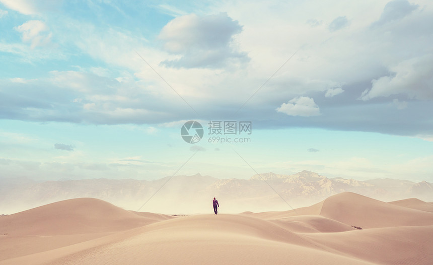 沙漠里的徒步旅行者看日出图片