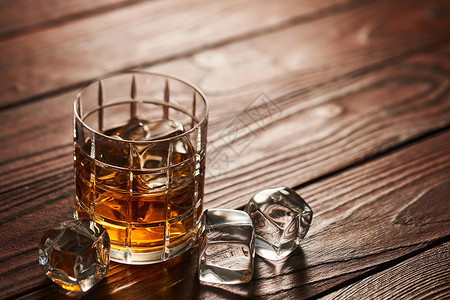 小麦芽杯威士忌加冰块乡村木桌上,背景