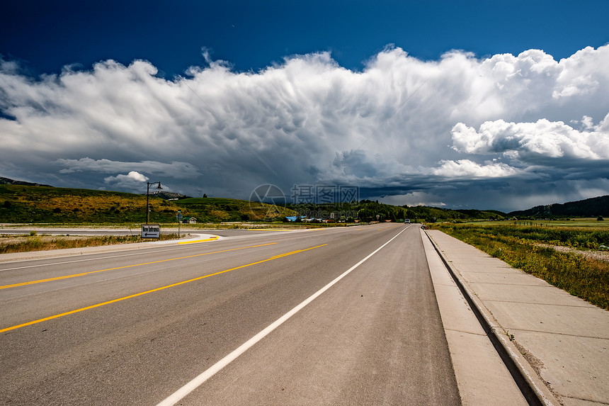 美国怀俄明州空旷的公路暴风雨的云层图片