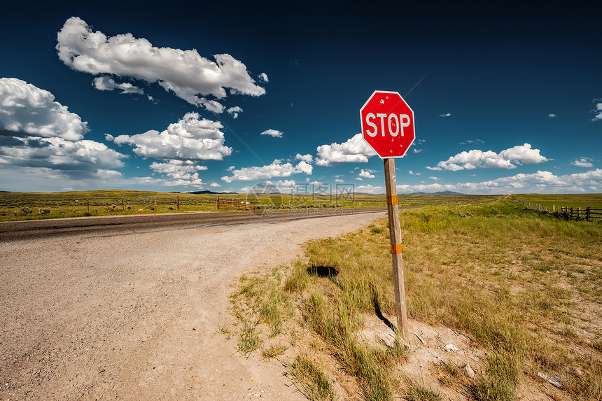 美国怀俄明州空旷公路上弹孔的停车标志图片