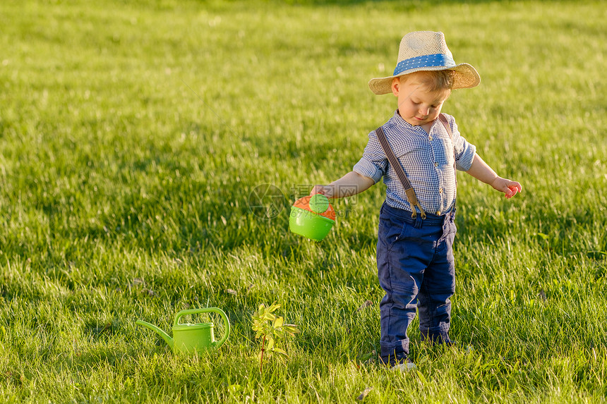 户外幼儿的肖像农村场景岁小男孩戴草帽用浇水罐图片