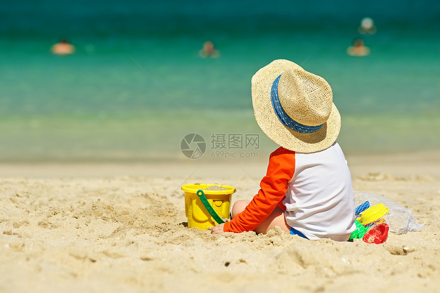 两岁的蹒跚学步的孩子海滩上玩耍两岁的蹒跚学步的男孩海滩上玩海滩玩具图片