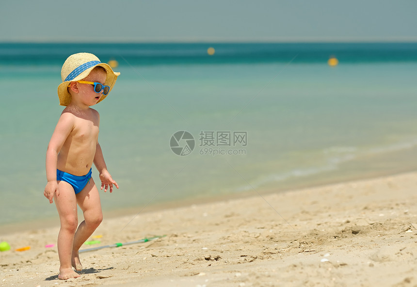 海滩上的蹒跚学步的男孩两岁的蹒跚学步的男孩海滩上图片