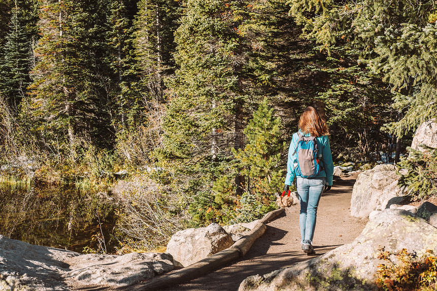 游客科罗拉多州熊湖附近的小径上秋天,洛基山公园的熊湖附近散步的女游客科罗拉多,美国图片