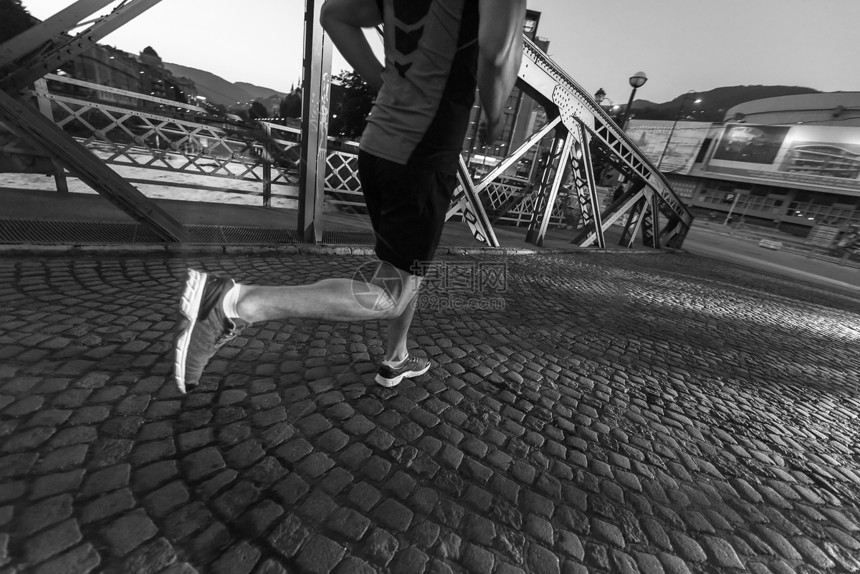 城市运动,轻健康的男人城市的清晨慢跑过桥图片