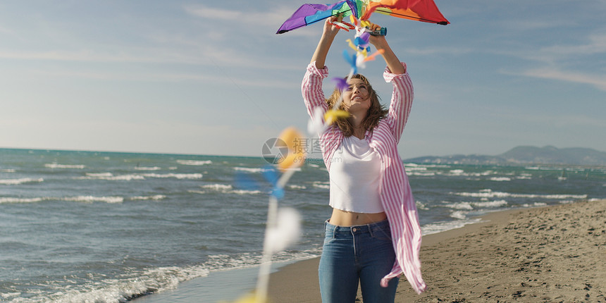 相爱的夫妇海滩上放风筝,秋天的日子里玩得很开心图片