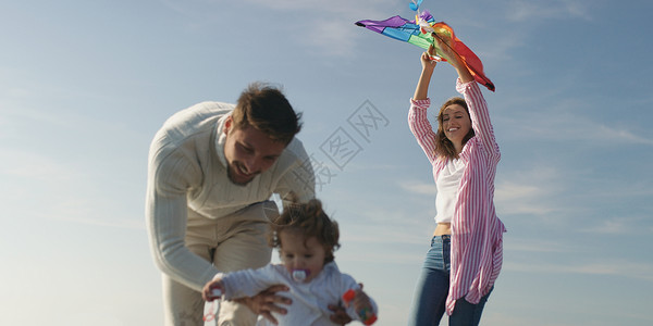 家人孩子们秋天的白天海滩上休息玩得开心图片