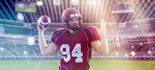 名四分卫美国足球运动员用灯光照明弹大型现代体育场投掷球背景图片
