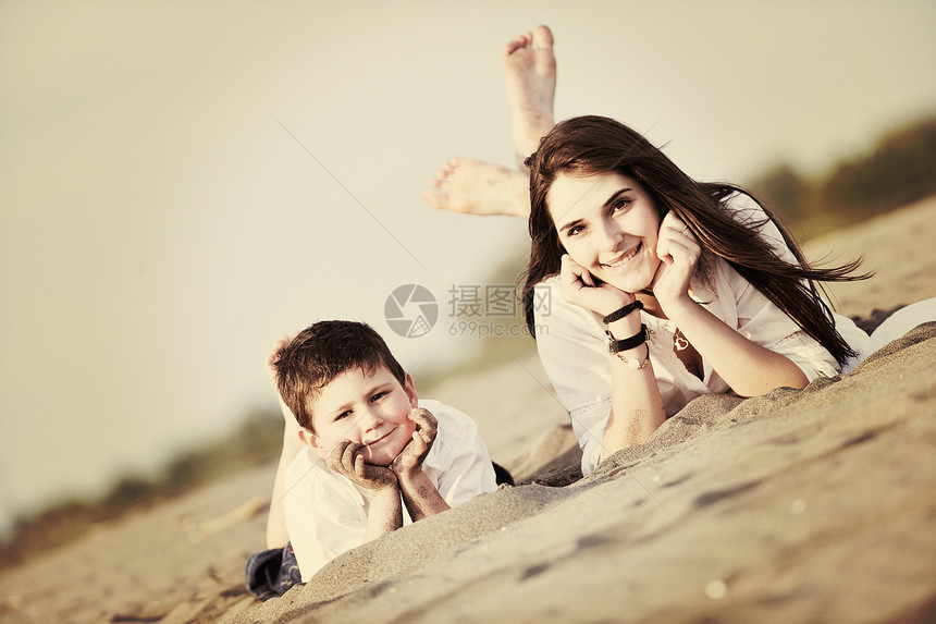 快乐的轻母亲儿子放松玩沙滩游戏夏天的季节图片