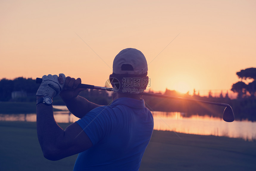 高尔夫球手美丽的日落时与司机球场上打远射高尔夫球手击球远射图片