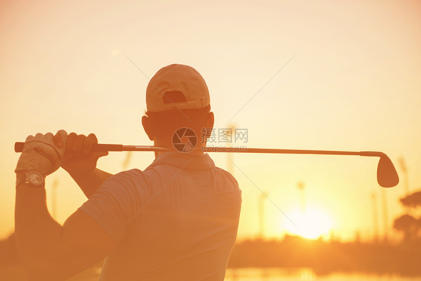 高尔夫球手美丽的日落时与司机球场上打远射高尔夫球手击球远射图片