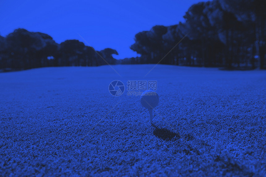 高尔夫球发球台上高尔夫球杆美丽的球场与新鲜的绿草双调图片