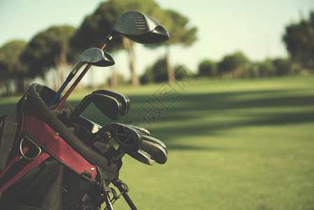 美丽的日出时,球场上高尔夫球袋的特写镜头,球杆球前球场上的特写高尔夫包图片