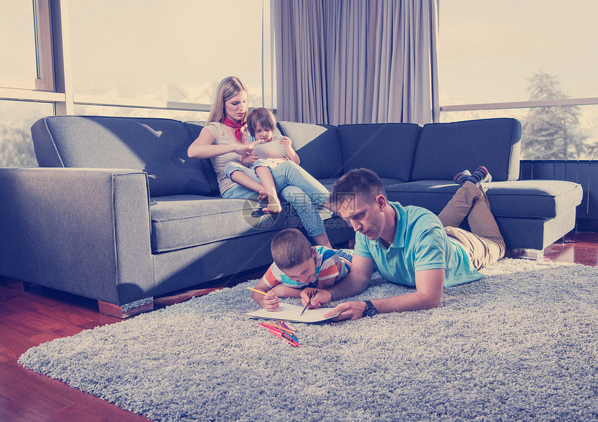 快乐的轻家庭家里玩,地板上用平板电脑儿童绘图集轻夫妇花时间孩子们图片
