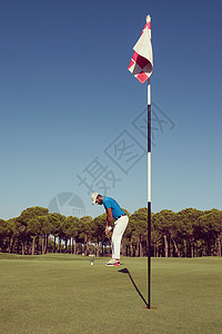 高尔夫球手击球与司机球场上美丽的晴天高尔夫球运动员晴天击球图片