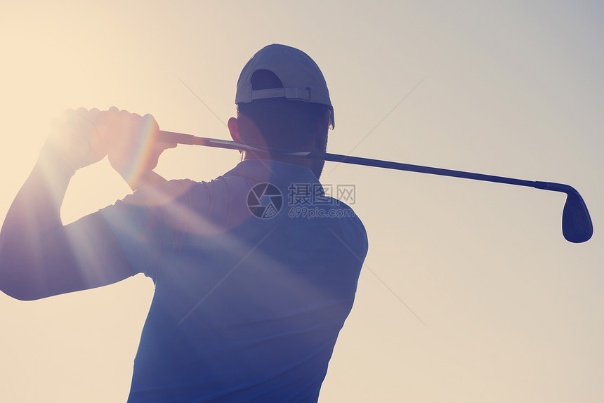 高尔夫球手击球与球杆美丽的早晨与太阳耀斑背景高尔夫球员击球图片