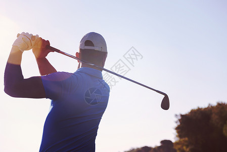 高尔夫球手击球与球杆美丽的早晨与太阳耀斑背景高尔夫球员击球背景图片
