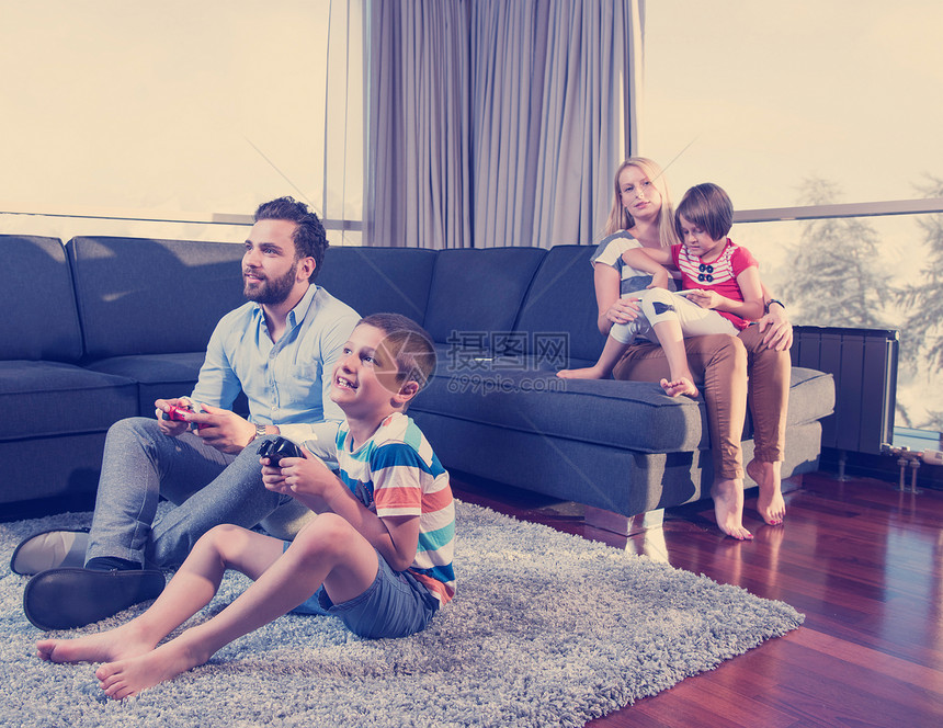 幸福的家庭爸爸妈妈孩子们玩电子游戏,爸爸儿子地板上玩电子游戏快乐的家庭玩电子游戏图片