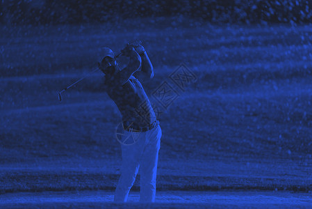 煤仓高尔夫球手日落时击中了个沙坑高尔夫球手高尔夫球场沙坑中射出球,背景色调为美丽的日落背景