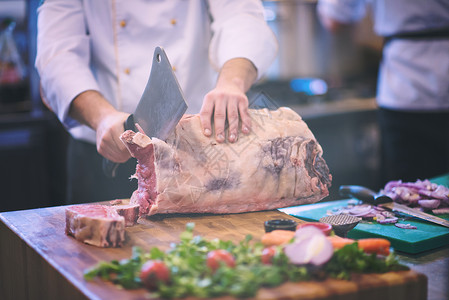 厨师餐厅厨房用斧头木板上切大块牛肉厨师切大块牛肉图片