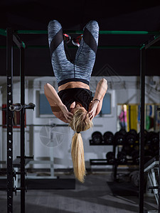 运动员妇女腹肌练,倒挂水平杆交叉健身健身房女人腹肌练图片