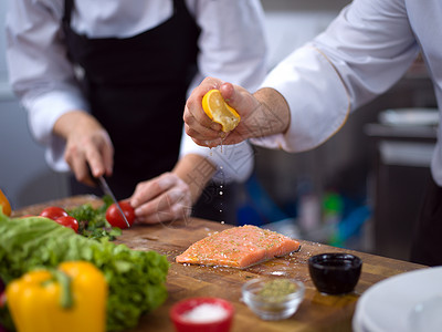 厨师手准备腌制鲑鱼鱼片,以便餐厅厨房煎炸厨师手准备腌制的鲑鱼鱼图片