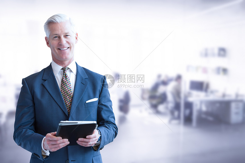 他的现代办公室前用平板电脑的高级商人的肖像他办公室的高级商人图片