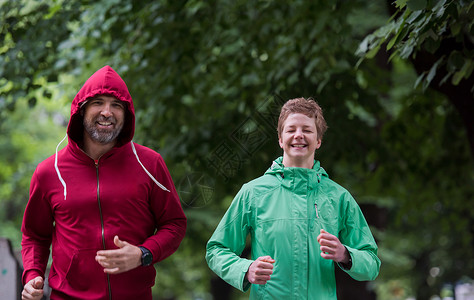 晨练慢跑夫妇健康慢跑夫妇城市公园跑步,跑步队参加晨训图片