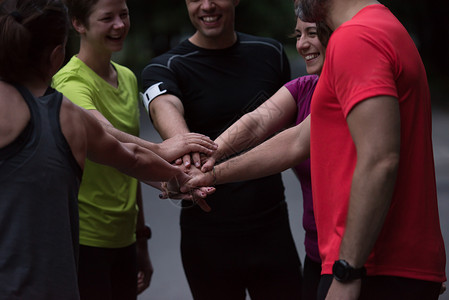 跑步者互相击掌群健康的跑步者训练后互相击掌庆祝成功图片