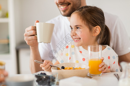 吃早餐女孩家庭,饮食人的快乐的父亲女儿家里吃早餐幸福的家庭家里喝果汁早餐背景
