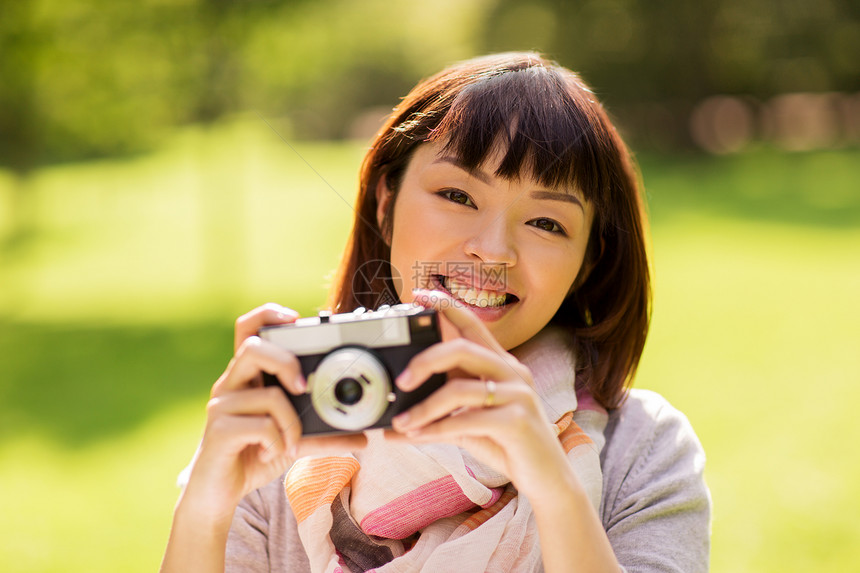 摄影,休闲人的快乐微笑的亚洲轻妇女与电影相机户外快乐的轻亚洲妇女与电影相机户外图片