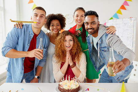 朋友聚公司人的快乐的同事队与非酒精饮料蛋糕庆祝生日办公室聚会快乐的同事办公室生日聚会上吃蛋糕背景