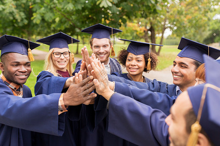 教育毕业人的群快乐的国际学生穿着灰浆板学士学位服,身高五快乐的学生迫击炮板上高五背景图片