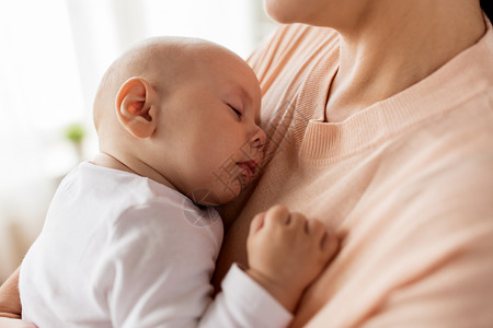 家庭,母亲人的亲密的母亲抱着熟睡的小男孩紧紧抱着熟睡的婴儿的母亲图片