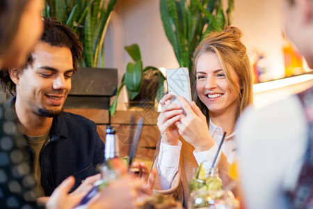 休闲,人技术的快乐的朋友与智能手机餐厅吃喝智能手机的朋友餐馆吃饭图片