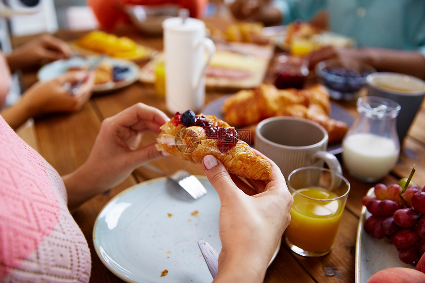食物,烘焙人们的女人的手吃羊角包早餐桌子上吃羊角包早餐的女人的手图片