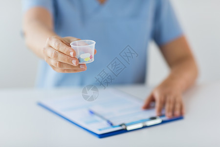 医学,医疗保健人的护士医生与药丸医疗杯剪贴板用药杯里的药丸医生图片