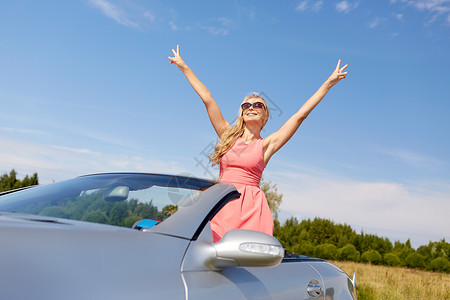 旅行,暑假,公路旅行人们的快乐的轻女人戴着太阳镜敞篷车上享受阳光开敞篷车的快乐轻女人背景图片