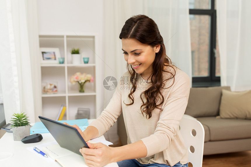 自由职业,技术教育理念快乐的微笑女人与平板电脑笔记本电脑工作学家里学生自由职业者与平板电脑家里图片